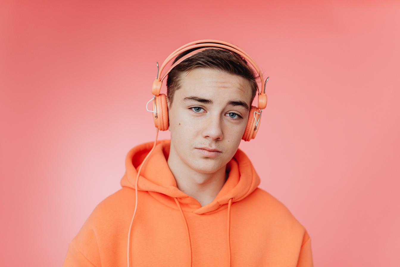 A Man Wearing Headphones and an Orange Hoodie Sweater